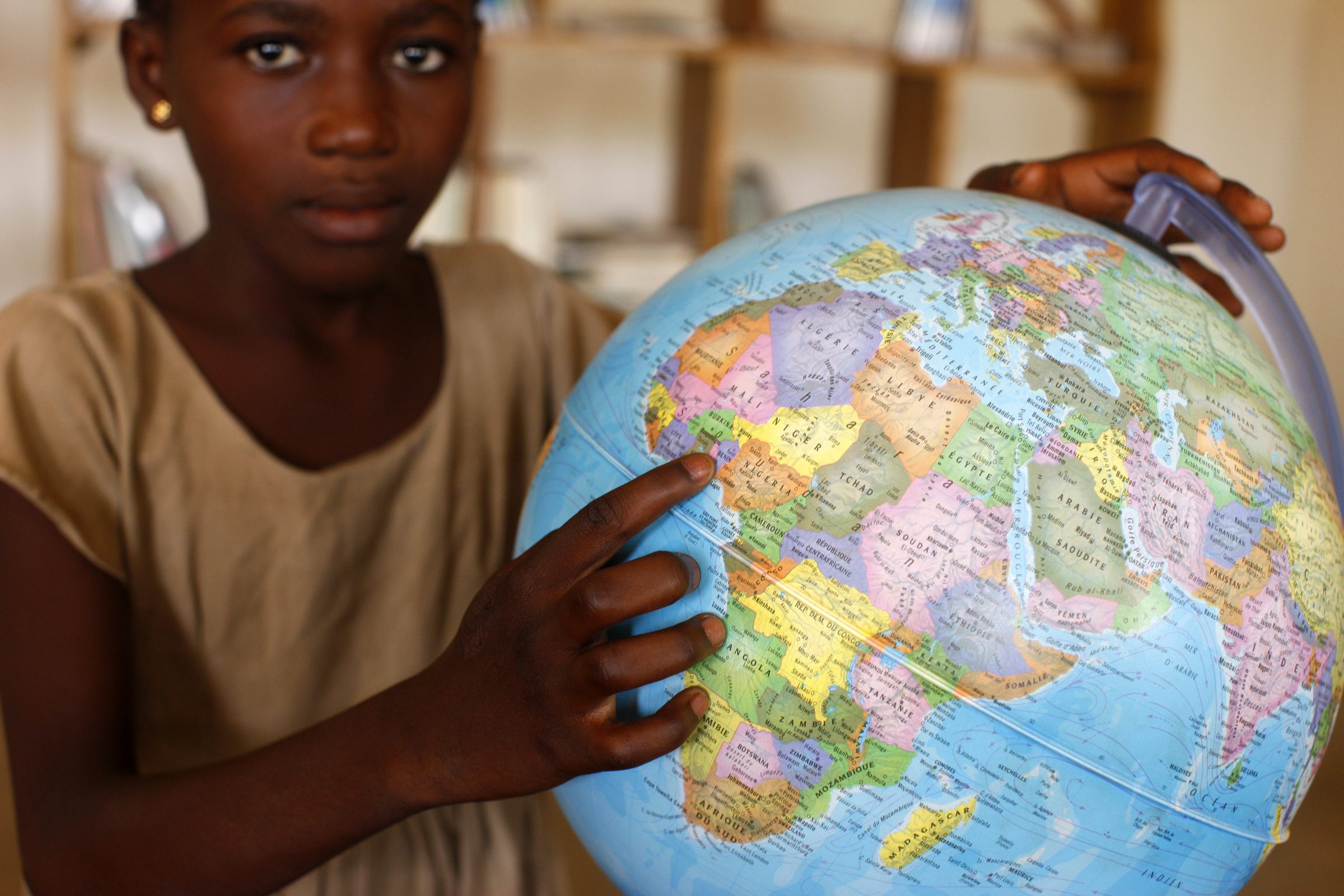 Student pointing to Africa on a globe